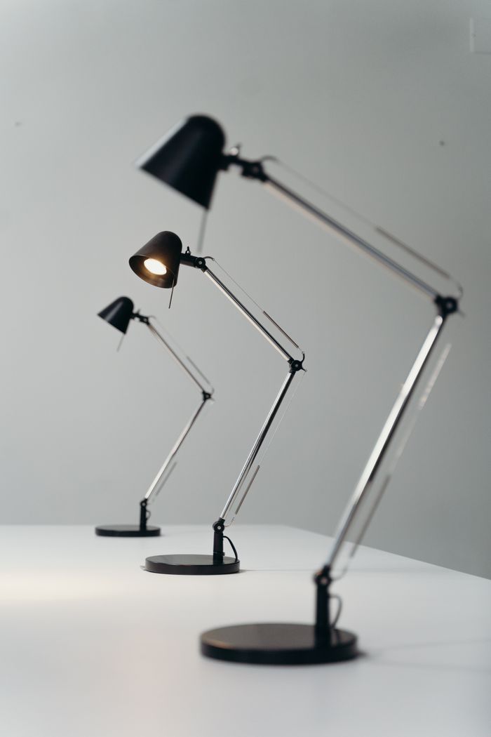 Crafting Captivating Headlines: Your awesome post title goes here Three modern black desk lamps on a white desk against a gray background, showcasing sleek design.